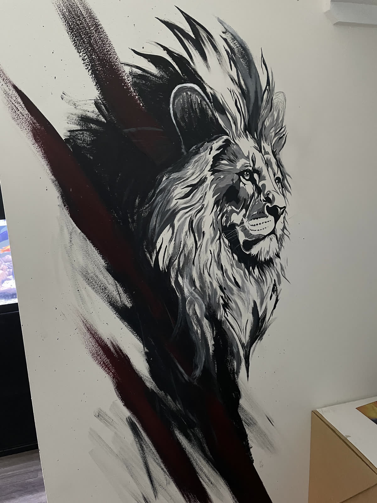 Black, white and crimson lion mural hand-painted by the Astro & Aura artists across an interior feature wall in Charlotte